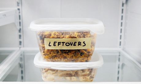 A plastic tub in on the fridge shelf, labelled "leftovers"