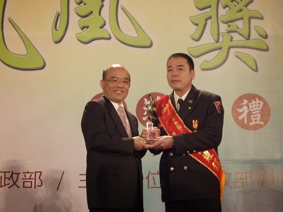 江耀鈺(右)於民國九十五年當選全國消防楷模，由時任台北縣長蘇貞昌(左)授獎。(江耀鈺提供)