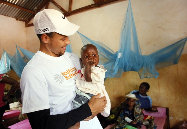 金州勇士隊球員柯瑞在 2013 年 7 月 30 日參與「Nothing But Nets」發送防治瘧疾蚊帳的行程，在坦尚尼亞尼亞 Nyarugusu 難民營醫療中心留影