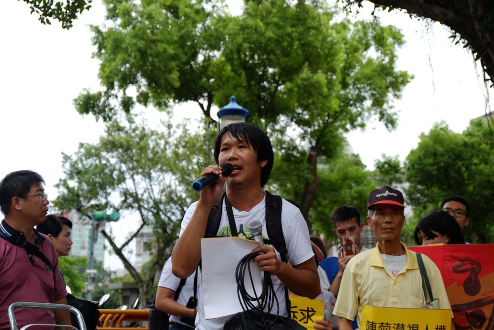王繼維拿著麥克風，在台北的炙熱太陽下，賣力地喊出訴求。
